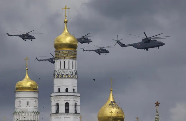 Russian military helicopters fly over Ivan the Great bell-tower and Moscow's Kremlin during a general rehearsal for the Victory Day military parade which will take place at Moscow's Red Square on May 9 to celebrate 71 years after the victory in WWII in Moscow, Russia, on Thursday, May 5, 2016. (Photo by Ivan Sekretarev/AP Photo)
