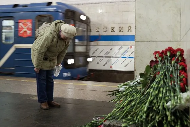 A woman pays her respects at a symbolic memorial at Tekhnologichesky Institute subway station in St. Petersburg, Russia, Tuesday, April 4, 2017. A bomb blast tore through a subway train deep under Russia's second-largest city St. Petersburg Monday, killing several people and wounding many more in a chaotic scene that left victims sprawled on a smoky platform.  (Photo by Dmitri Lovetsky/AP Photo)