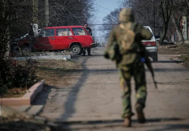 A Ukrainian serviceman walks along a street near the front line near the city of Novoluhanske in the Donetsk region, Ukraine on February 22, 2022. (Photo by Gleb Garanich/Reuters)