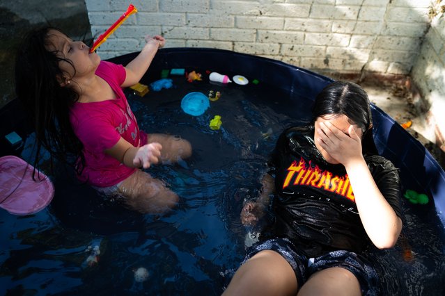 Ashley Cardona, 5, and Nayelli Interiano, 12, both of DC, play in a small pool outside of a pool in Washington, DC on the hot afternoon of Friday, June 21, 2024.  (Photo by Sarah L. Voisin/The Washington Post)
