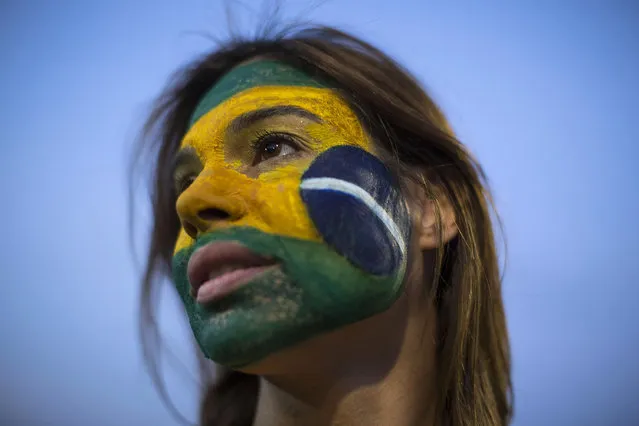 An anti-government demonstrator shows off her Brazilian flag motif face paint outside Congress in Brasilia, Brazil, Wednesday, May 11, 2016. Brazil's Senate is nearing a historic vote on impeaching President Dilma Rousseff, likely ending 13 years of government by her party amid a spate of crises besetting Latin America's largest nation. (Photo by Felipe Dana/AP Photo)