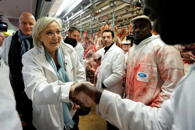 Marine Le Pen (L), French National Front (FN) political party candidate for French 2017 presidential election, speaks with employees as she visits the meat pavilion at the Rungis international food market, near Paris, during her campaign, France, April 25, 2017. (Photo by Charles Platiau/Reuters)