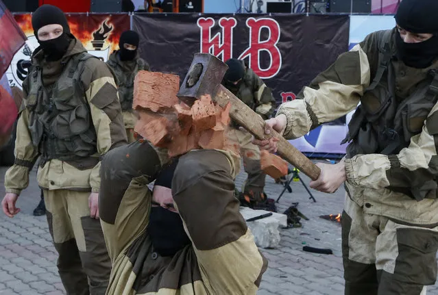 A member of a military-patriotic club smashes bricks with a hammer on the head of a fellow during a show, dedicated to the opening of the summer motorbike season, at the Central Park of Krasnoyarsk, Russia on April 30, 2017. (Photo by Ilya Naymushin/Reuters)
