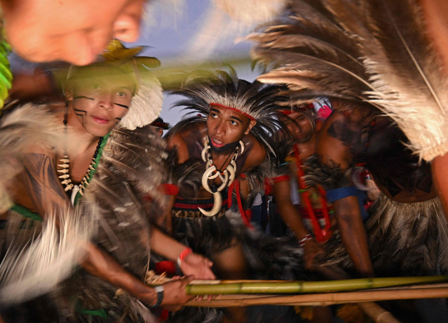 Indigenous men perform a ritual during a protest march at the Terra Livre Indigenous camp in Brasilia on April 26, 2023. The camp will run until April 29, 2023, and is focused on raising awareness about indigenous rights and land issues and promoting indigenous culture. (Photo by Carl de Souza/AFP Photo)