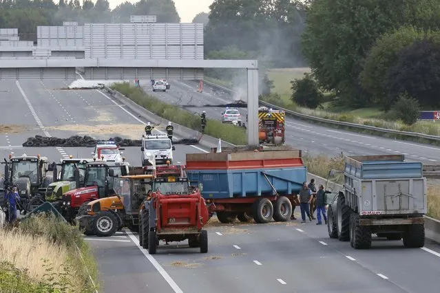 French farmers block the A1 Lille-Paris highway early in the morning in Seclin, northern France, to protest against a squeeze in margins by retailers and food processors, July 22, 2015. (Photo by Pascal Rossignol/Reuters)
