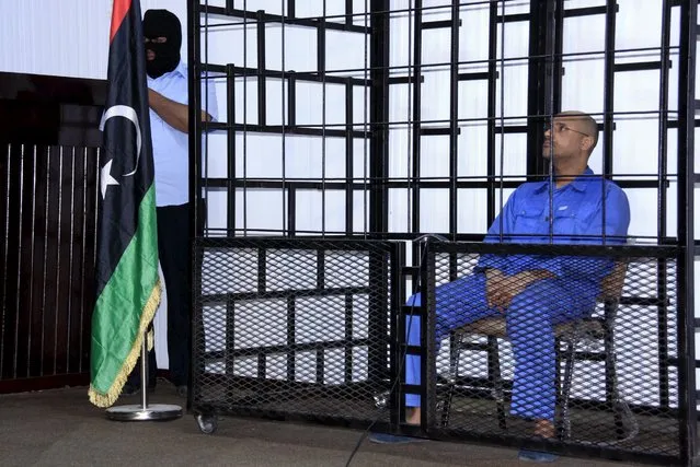 Saif al-Islam Gaddafi, son of late Libyan leader Muammar Gaddafi, attends a hearing behind bars in a courtroom in Zintan, Libya in this May 25, 2014 file photo. The Libyan court has sentenced Saif to death. The verdict was passed on Saif in absentia since he has been held since 2011 by a former rebel group in Zintan that opposes the Tripoli government. (Photo by Reuters/Stringer)