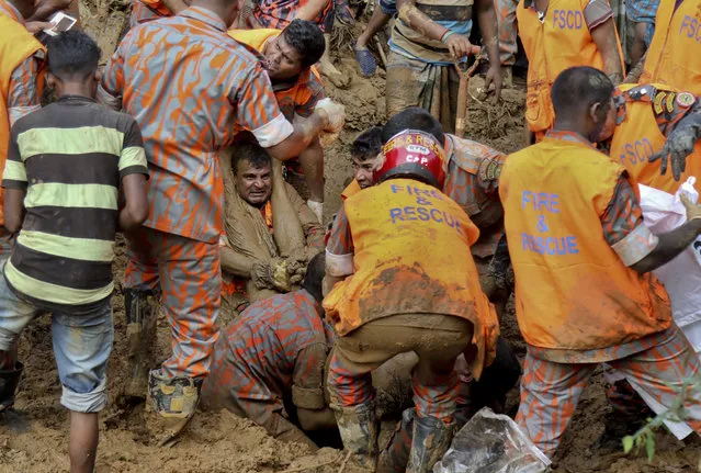 Rescuers pull out the dead body of a victim after Tuesday's massive landslide in Rangamati district, Bangladesh, Wednesday, June 14, 2017. Rescuers struggled on Wednesday to reach villages hit by massive landslides that have killed more than a hundred while also burying roads and cutting power in southeastern Bangladesh, officials said. (Photo by AP Photo)