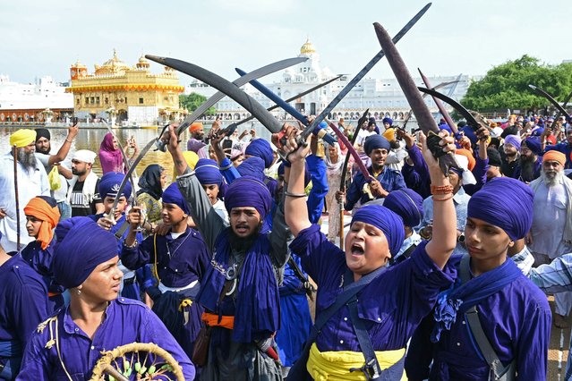 Sikh youths hold swords as they raise slogans during a religious procession from the Gurudwara Ramsar to Akal Takht Sahib at the Golden Temple in Amritsar on September 4, 2024, on the occasion of the anniversary of installation of the Sikh holy book Guru Granth Sahib. (Photo by Narinder Nanu/AFP Photo)