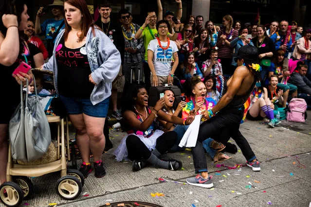 Whipping out phones and laughing, young women react to a man vigorously dancing at them during the 40th annual Seattle Pride Parade Sunday, June 29, 2014, in Seattle, Wash. This year's theme was “Generations of Pride”. (Photo by Jordan Stead/AP Photo/Seattlepi.com)