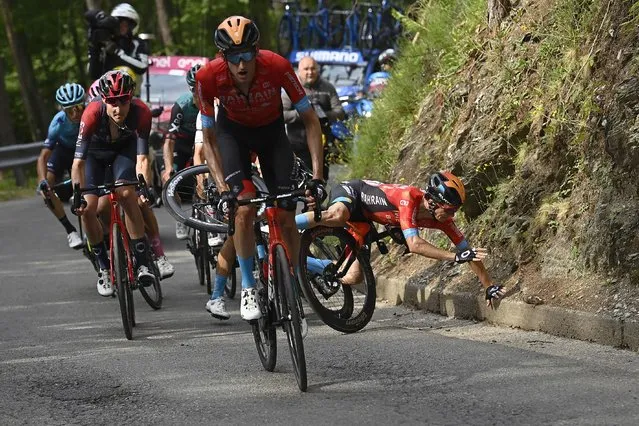 Spain's Pello Bilbao Lopez De Armentia, right, falls during the 16th stage of the Giro D'Italia cycling race, from Salò to Aprica, Italy, Tuesday, May 24, 2022. (Photo by Fabio Ferrari/LaPresse via AP Photo)