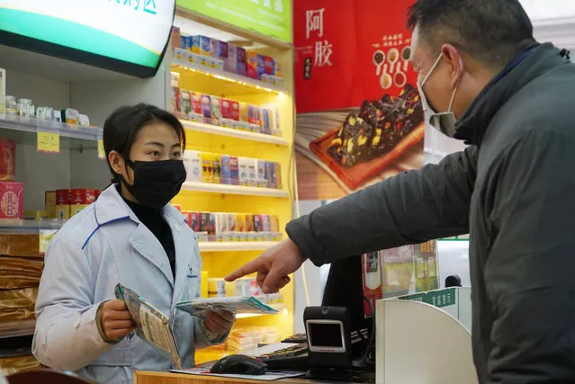 Staff sell masks at a Yifeng Pharmacy in Wuhan, Chin, Wednesday, January 22, 2020. Pharmacies in Wuhan are restricting customers to buying one mask at a time amid high demand and worries over an outbreak of a new coronavirus. The number of cases of the new virus has risen over 400 in China and the death toll to 9, Chinese health authorities said Wednesday. (Photo by Dake Kang/AP Photo)