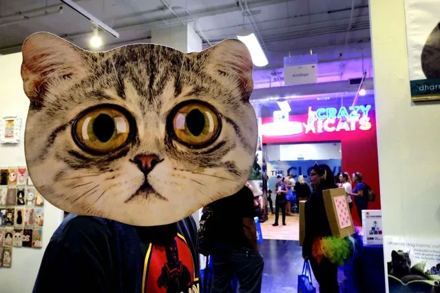 Jean-Pierre Giagnoli walks through a crowded area of vendors hawking cat related goods at CatCon LA in Los Angeles, on Sunday, June 26, 2016. (Photo by Richard Vogel/AP Photo)