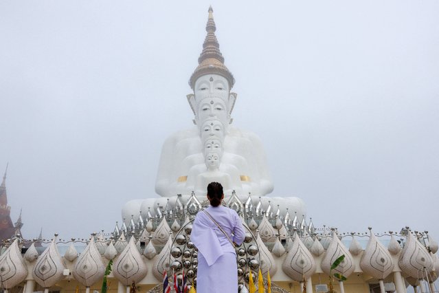 A devotee prays in front of big Buddha statues in the early morning mist, at Wat Phra That Pha Sorn Kaew temple, in Khao Kho, Phetchabun province, Thailand, on September 21, 2024. (Photo by Athit Perawongmetha/Reuters)