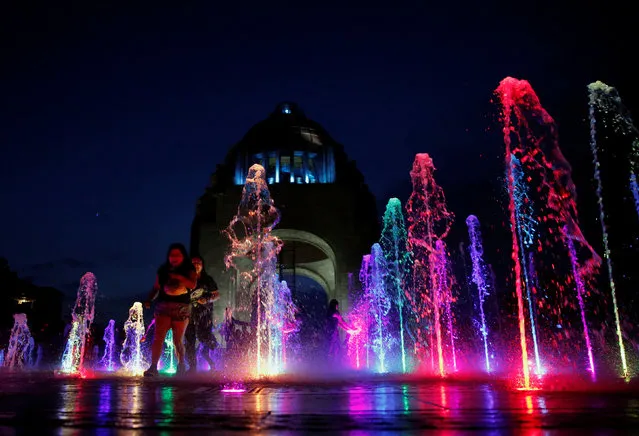 People are seen by an illuminated fountain at the Monument of the Revolution in Mexico City, Mexico on August 5, 2017. (Photo by Henry Romero/Reuters)