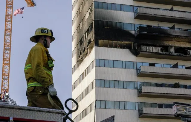 Los Angeles Fire Department personnel investigate the scene of a fire at a multi-story building on Wilshire Boulevard in Los Angeles, California, U.S. January 29, 2020. (Photo by Kyle Grillot/Reuters)