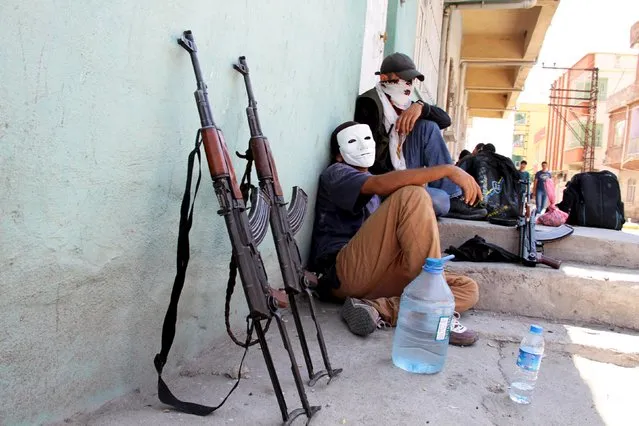 Masked members of YDG-H, youth wing of the outlawed Kurdistan Workers Party (PKK), sit next to their weapons in Silvan, near the southeastern city of Diyarbakir, Turkey, August 17, 2015. The PKK has attacked military targets on a near-daily basis since the Turkish government launched air strikes on rebel camps in northern Iraq on July 25, wrecking a two-year-old ceasefire. (Photo by Sertac Kayar/Reuters)
