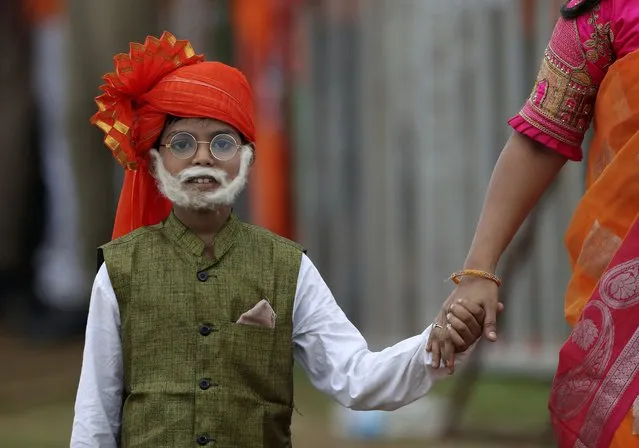 A young supporter of ruling Bharatiya Janata Party (BJP) dressed like Indian Prime Minister Narendra Modi arrives with his mother during a public meeting addressed by Modiin Hyderabad, India, Sunday, July 3, 2022. (Photo by Mahesh Kumar A./AP Photo)