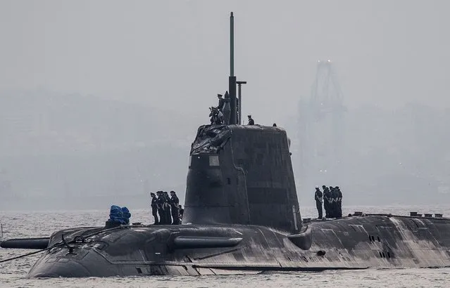 A picture taken on July 20, 2016 in the port of Gibraltar shows the nuclear submarine HMS Ambush (C) making an unscheduled stop in Gibraltar due to a sustained damage to its conning tower after hitting a vessel. (Photo by D.M. Parody/AFP Photo)