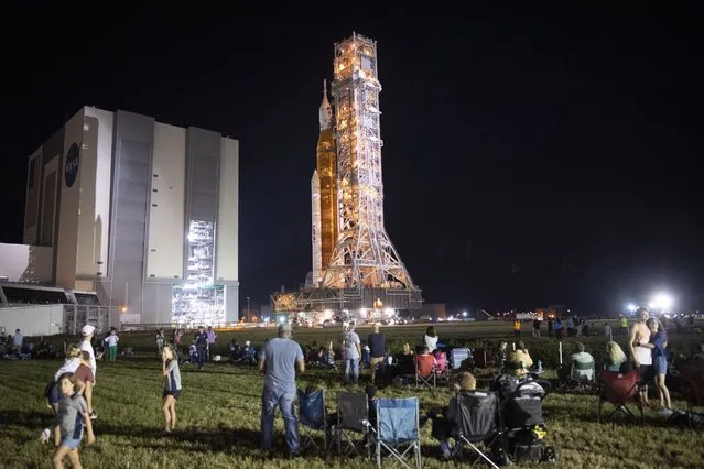 A handout picture made available by the National Aeronautics and Space Administration (NASA) shows invited guests and NASA employees watch as NASA’s Space Launch System (SLS) rocket with the Orion spacecraft aboard is rolled out of the Vehicle Assembly Building to Launch Pad 39B, at NASA’s Kennedy Space Center in Merrit Island, Florida, USA, 16 August 2022. NASA’s Artemis I mission is the first integrated test of the agency’s deep space exploration systems: the Orion spacecraft, SLS rocket, and supporting ground systems. Launch of the uncrewed flight test is targeted for no earlier than 29 August. (Photo by Joel Kowsky/EPA/EFE)