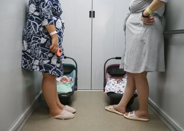 Mothers with their new-borns ride an elevator down to a bomb shelter organized below a children hospital during an air-raid alarm in Odesa, Ukraine, 22 August 2022. The underground shelter provides all necessary services for pregnant women, young mothers and their babies. Russian troops entered Ukrainian terrotoriy on 24 August, starting a conflict that has provoked destruction and a humanitarian crisis. (Photo by EPA/EFE/Stringer)