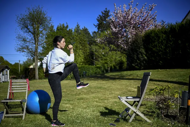 Fitness coach Gabrielle Friscira gives a lesson by videoconference in Saint-Remy-lHonore, west of Paris, on April 15, 2020, on the 30th day of a strict lockdown in France aimed at curbing the spread of the COVID-19 pandemic, caused by the novel coronavirus. (Photo by Franck Fife/AFP Photo)