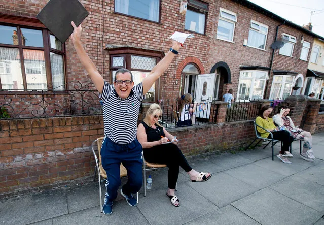 Residents of Dovercliff Road take part in games of Bingo held by neighbour David Walsh (L), in Liverpool, Britain, 25 April 2020. During the Covid 19 pandemic members of the public have been finding various ways to entertain themselves whilst sticking to government guideline and observing social distancing. (Photo by Peter Powell/EPA/EFE)