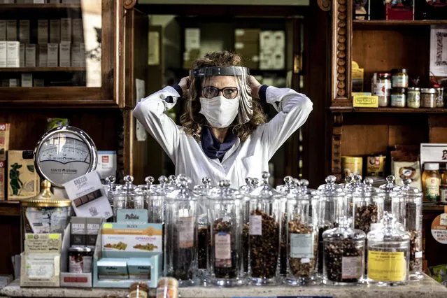 Assunta owner of the herbalist's shop Il Germoglio is portrayed while adjusting her protective gear against Covid-19 on May 2, 2020 in Rome, Italy. Italy will remain on lockdown to stem the transmission of the Coronavirus (Covid-19), slowly easing restrictions. Following the announcement made by Italy’s Prime Minister Giuseppe Conte from 4 May people will be allowed to do outdoor exercise and the chance to visit family members, all while maintaining social distancing. Gatherings of any kind, private or public, will remain strictly banned. Public parks, gardens and villas will reopen but mayors will have the power to close them if necessary. People will be allowed to walk and jogging away from their home so long as they practice social distancing: two metres apart for joggers, one metre for walkers. Restaurants and bars will be allowed to operate a take-away service - in addition to home delivery which is already permitted.(Photo by Alessandra Benedetti - Corbis/Corbis via Getty Images)