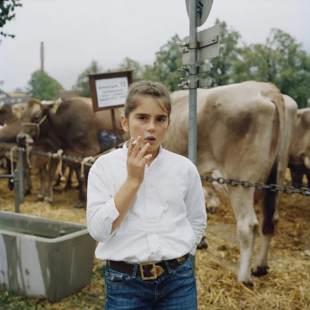 A girl smoking at a cattle show in Appenzell, Switzerland. “Appenzell is a beautiful and very odd place. It’s a tiny rural town in the east of Switzerland, built in the 16th century. Here, all the cliches are true: the fondue and the yodelling, the pink cows and the magnificent ski slopes. It’s also a place with very local habits. They still celebrate the new year according to the Julian calendar. And every October, they hold the Viehschau cattle show – a beauty show, but for cows. I first visited it in 2013. As soon as I started taking photographs, I noticed that many of the younger kids were passing around cigarettes, smoking one after another”. (Photo by Jiří Makovec)