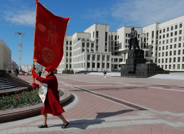 A woman carries a Soviet banner at Independence Square on the 150th birth anniversary of Soviet state founder Vladimir Lenin, amid the coronavirus disease (COVID-19) outbreak, in Minsk, Belarus on April 22, 2020. (Photo by Vasily Fedosenko/Reuters)
