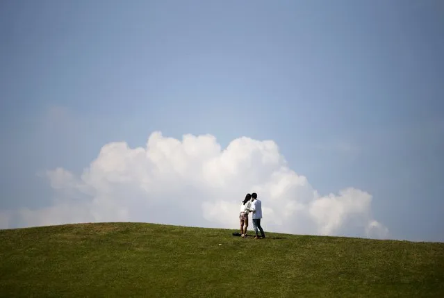 A couple takes a selfie on the top of a hill during a sunny day at Olympic Park in Seoul, South Korea, September 14, 2015. (Photo by Kim Hong-Ji/Reuters)