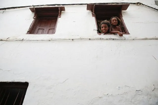 Girls look through the window of a house in Kasbah of the Udayas, a picturesque ancient part of Rabat September 21, 2014. (Photo by Damir Sagolj/Reuters)