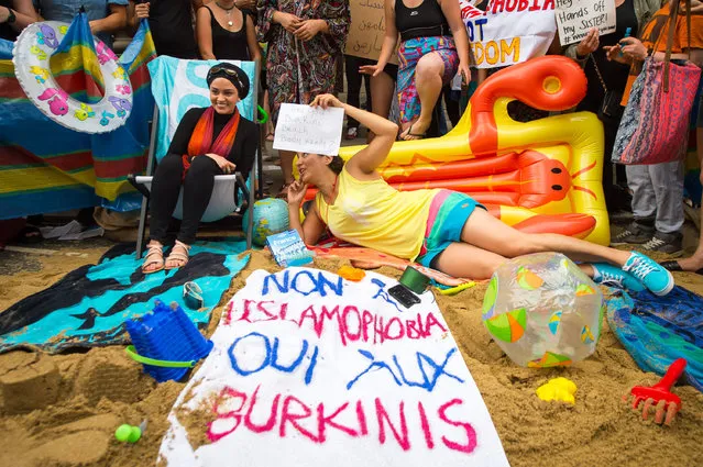 Demonstrators stage a beach party outside the French embassy in Knightsbridge, London, UK on August 25, 2016 to protest against the French government’s decision to ban women from wearing burkinis. (Photo by Dominic Lipinski/PA Wire)