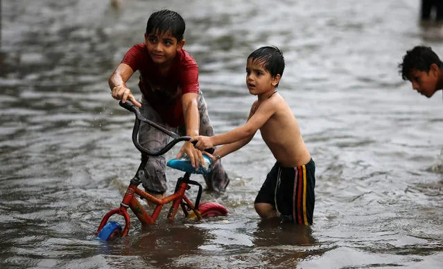 Children play on a flooded street during heavy rains in New Delhi, India, August 29, 2016. (Photo by Adnan Abidi/Reuters)