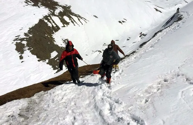 A handout picture made available by the Nepalese Army shows members of the army pulling the body of a trekker from the Thorung La mountain pass on the Annapurna Circuit, near Muktinath, in Mustang district, Nepal, 17 October 2014. In total seven dead bodies of trekkers including from Poland, Israel, China and Nepal have been brought to Kathmamdu over the past 24 hours, however the search operation continues for trekkers who went missing in a snowstorm, triggered by Cyclone Hudhud which brought heavy snowfall, which has so far claimed to lives of 29 people, though dozens remain unaccounted for. (Photo by EPA/Nepalese Army)