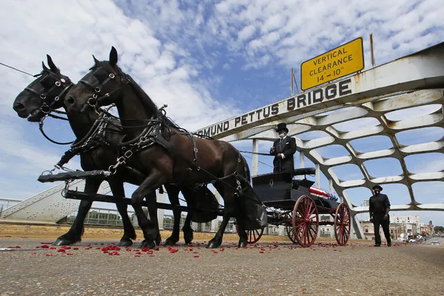 The casket of Rep. John Lewis moves over the Edmund Pettus Bridge by horse drawn carriage during a memorial service for Lewis, Sunday, July 26, 2020, in Selma, Ala. Lewis, who carried the struggle against racial discrimination from Southern battlegrounds of the 1960s to the halls of Congress, died Friday, July 17, 2020. (Photo by John Bazemore/AP Photo)