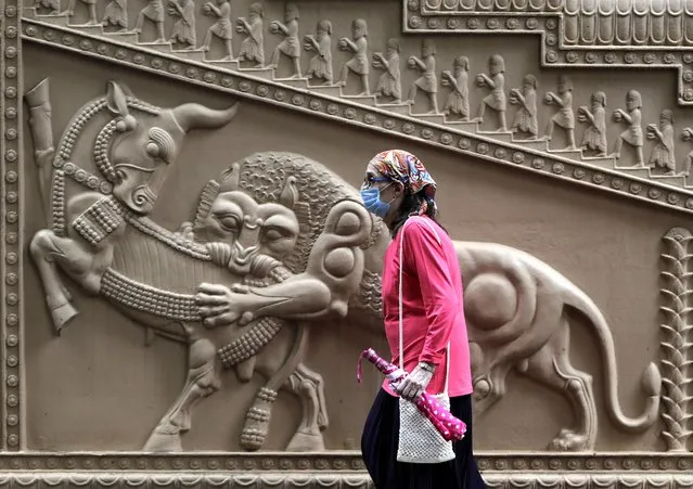 A Parsi woman wearing mask as a precaution against the coronavirus enters a prayer hall near a Fire Temple during Parsi New Year in Mumbai, India, Sunday, August 16, 2020. (Photo by Rajanish Kakade/AP Photo)