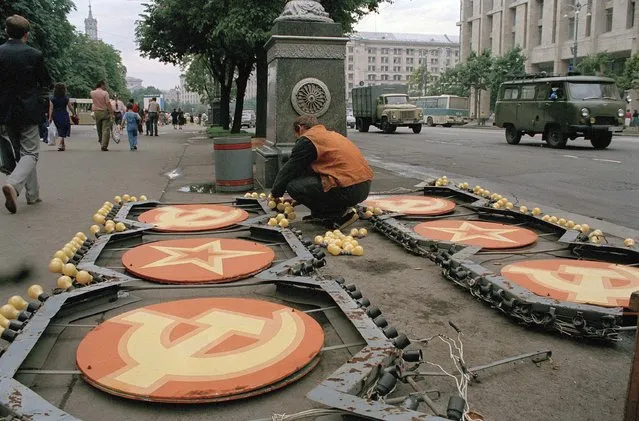 Ukrainian workers from the Kiev City Council dismantle and remove the illuminated hammer and sickle – symbols of the Soviet Union – that decorated the main street in downtown Kiev, July 31, 1991. The symbols are not considered representative of the independent Ukrainian Republic and will be replaced by flags for a visit by U.S. President George H. W. Bush. (Photo by Efrem Lukatsky/AP Photo/File)