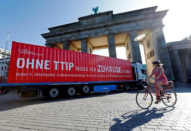 A truck is pictured in front of the Brandenburg Gate during a demonstration supporting Transatlantic Trade and Investment Partnership (TTIP) organized by the Initiative New Social Market Economy (Initiative Neue Soziale Marktwirtschaft) in Berlin, Germany September 15, 2016. The words read “Without TTIP I have to stay at home”. (Photo by Fabrizio Bensch/Reuters)