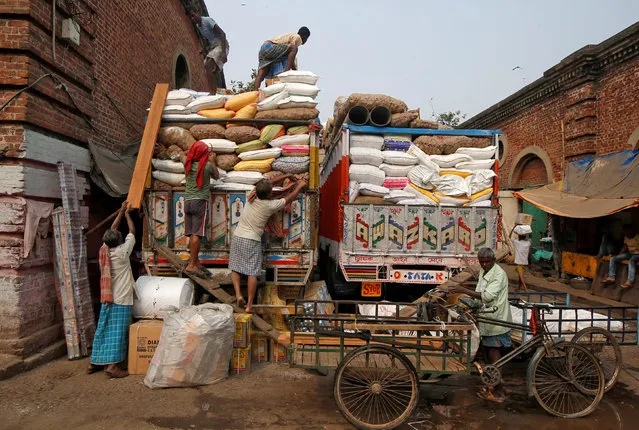 Labourers load sacks of grocery items onto supply trucks at a wholesale market in Kolkata, India, February 1, 2018. (Photo by Rupak De Chowdhuri/Reuters)