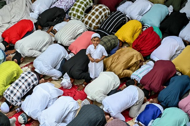 A child looks on as Muslim devotees offer Eid al-Adha prayers in Amritsar on June 7, 2025. (Photo by Narinder Nanu/AFP Photo)