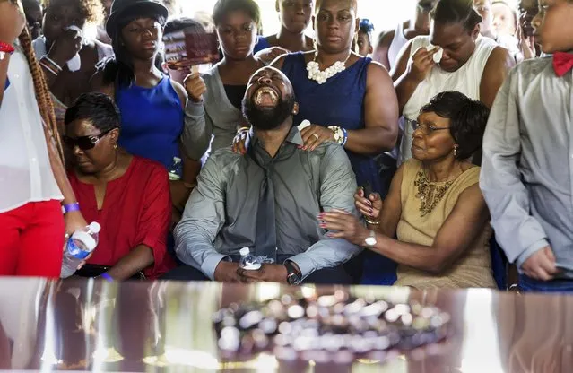 Michael Brown Sr. yells out as his son's casket is lowered into the ground at St. Peter's Cemetery in St. Louis, Missouri, in this August 25, 2014 file photo. (Photo by Richard Perry/Reuters)