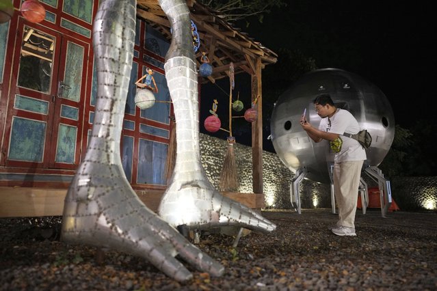 A participant takes photos near the statue of an alien, during the Indonesia UFO Festival, in Yogyakarta, Indonesia, Thursday, July 24, 2025. (Phoot by Dita Alangkara/AP Photo)