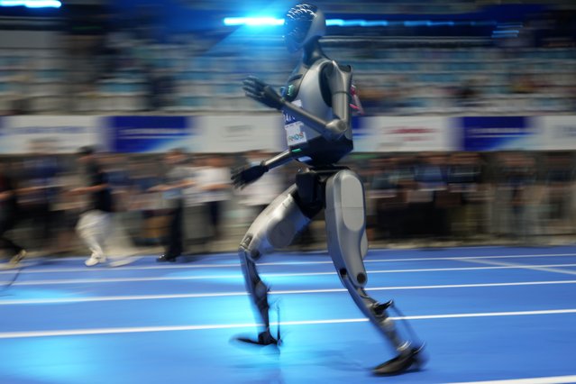 A humanoid robot prepares for its 100m race before the start of The World Humanoid Robot Games' opening ceremony in Beijing, China, August 14, 2025. (Photo by Ng Han Guan/AP Photo)