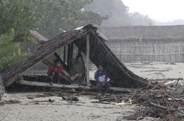 Residents take shelter in a damaged Nipa hut after strong winds and heavy rains brought on by Typhoon Hagupit battered Laiya town, San Juan city, Batangas province, south of Manila, December 9, 2014. (Photo by Romeo Ranoco/Reuters)