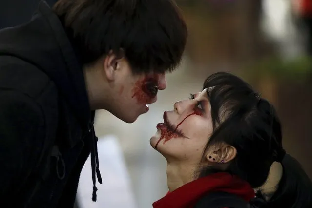 A man wearing Halloween face paint kisses his girlfriend during Halloween celebrations in the downtown of Seoul, South Korea, October 31, 2015. (Photo by Kim Hong-Ji/Reuters)