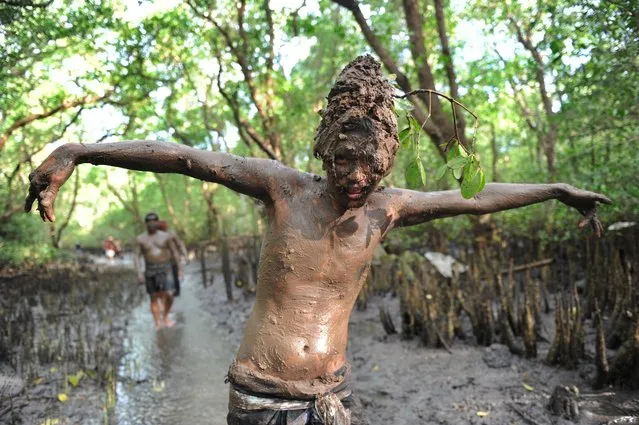 A Balinese boy puts mud on his body during a traditional mud baths known as Mebuug-buugan, in Kedonganan village, near Denpasar on Indonesia's resort island of Bali on March 18, 2018. The Mebuug-buugan is held a day after Nyepi aimed at neutralizing bad traits. (Photo by Sonny Tumbelaka/AFP Photo)