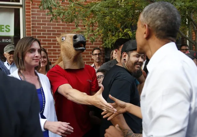 U.S. President Barack Obama greets a man wearing a horse mask during a walkabout in Denver in this July 8, 2014 file photo. (Photo by Kevin Lamarque/Reuters)