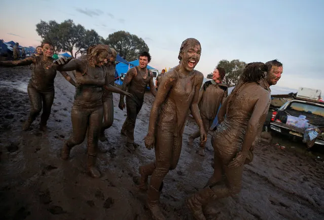 Mud-covered revellers roam a campsite on the final night of the Deni Ute Muster in Deniliquin, New South Wales, Australia, October 1, 2016. (Photo by Jason Reed/Reuters)