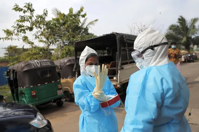 Sri Lankan health officials prepare to collect swab samples to test for COVID-19 in Colombo, Sri Lanka, Monday, November 23, 2020. (Photo by Eranga Jayawardena/AP Photo)