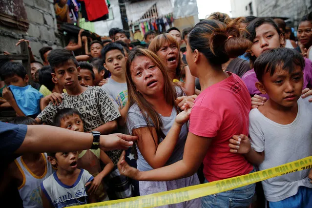 Janeth Mejos (C) reacts as the body of her father Paquito Mejos is taken out of their home shortly after he was killed in a police operation in Manila, Philippines October 14, 2016. (Photo by Damir Sagolj/Reuters)